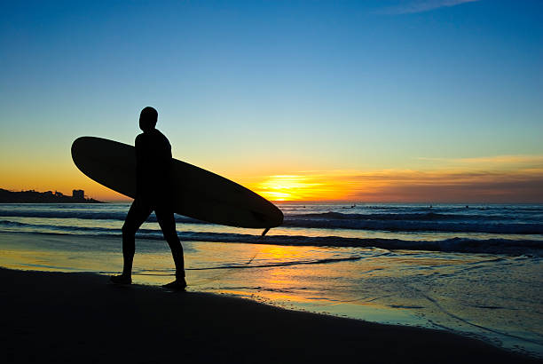 istock A surfer leaving the beach at sunset 105547354