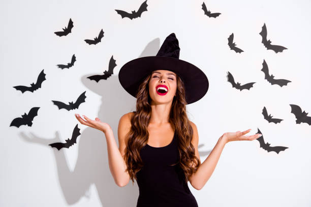 close up portrait of cruel paranormal curly lady with angry expression close eyes and laugh raised hand up isolated on white background - halloween horror vampire witch imagens e fotografias de stock