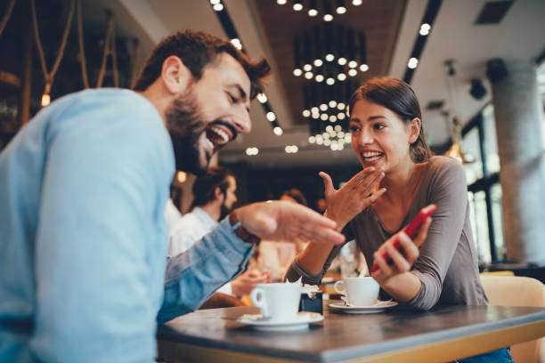 istock Young happy couple usinf smartphone in cafe 1055479542