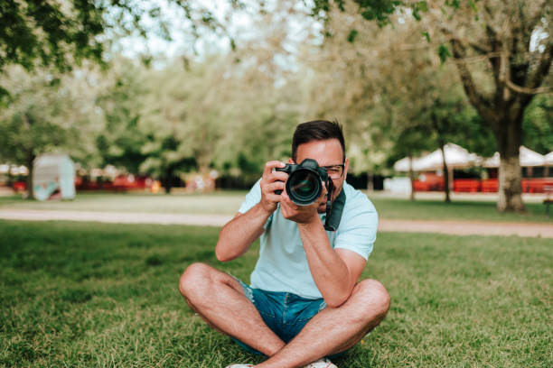 istock Front view of photographer sitting on the grass. 1055485380