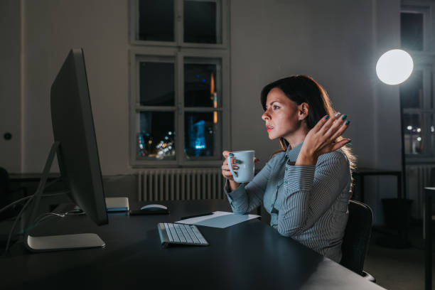 istock Angry businesswoman looking at computer screen at night. Side view. 1055485570