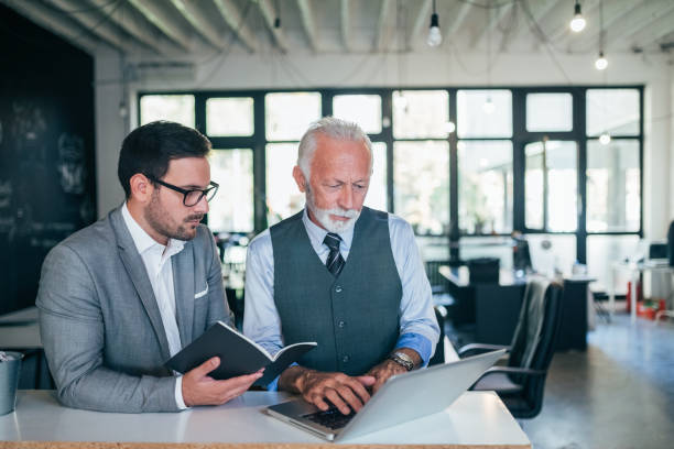 istock Handsome young and mature business men discussing work. 1055486104