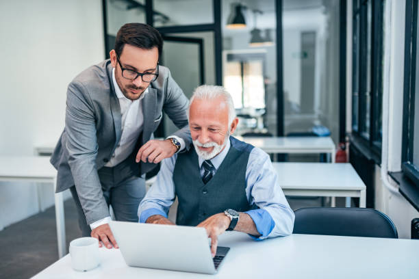 istock Young man working with boss or older employee in the office. 1055486428