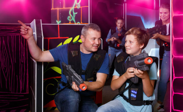 istock Ordinary boy and his father aiming laser guns 1055486852