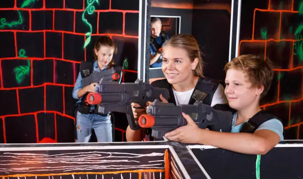 Photo of Mother and son with laser pistols playing laser tag