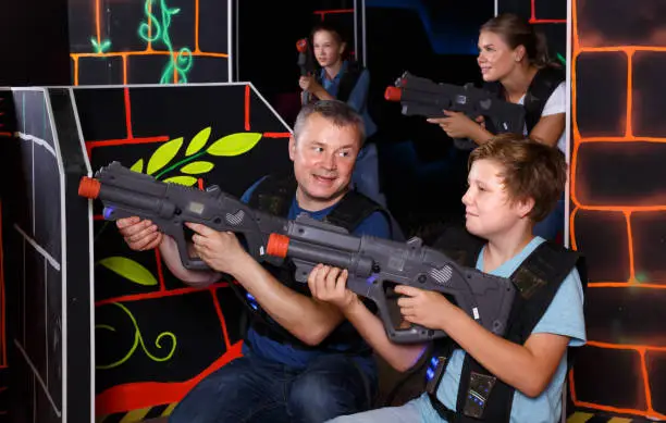 Photo of Glad boy and his father aiming laser guns