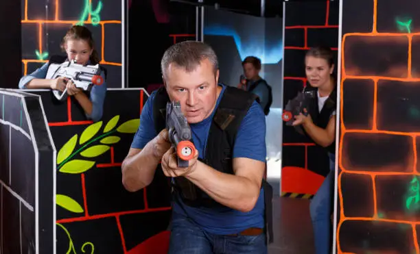 Photo of Portrait of man with laser gun having fun