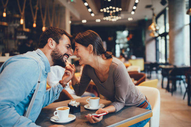 istock Young happy couple usinf smartphone in cafe 1055492276