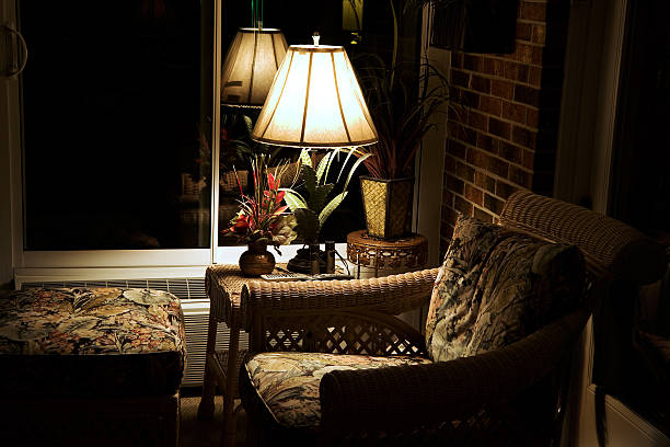 Modern house garden terrace (patio) lined with bricks with garden furniture at night lighting by lamps