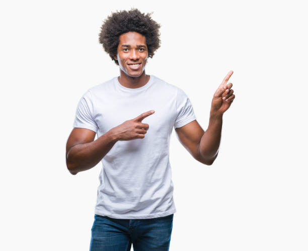 istock Afro american man over isolated background smiling and looking at the camera pointing with two hands and fingers to the side. 1055503452