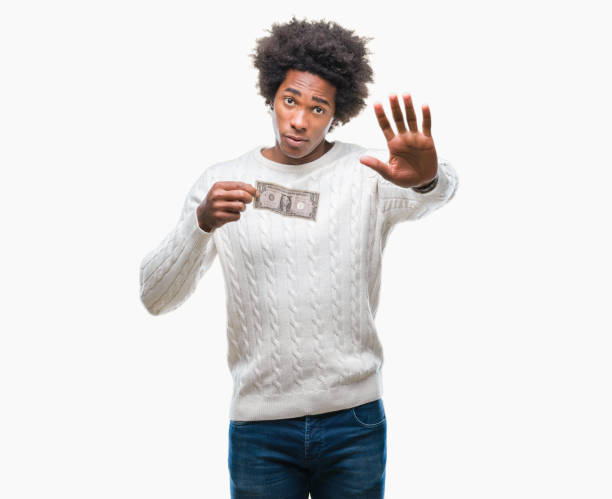 istock Afro american man holding one dollar over isolated background with open hand doing stop sign with serious and confident expression, defense gesture 1055504704