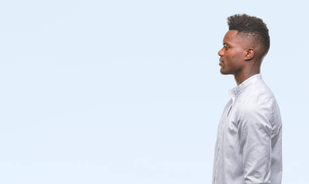 istock Young african american man over isolated background looking to side, relax profile pose with natural face with confident smile. 1055505576