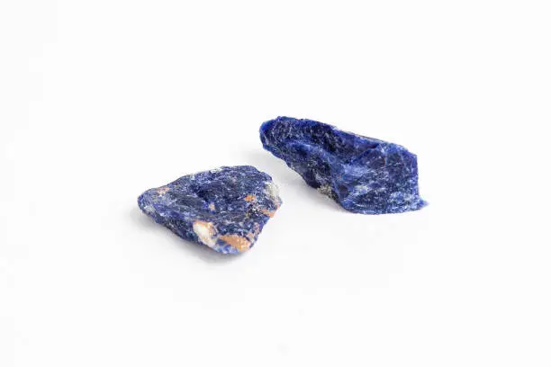 Two raw ores of lapislazuli on white background. Lapis lazuli is a deep blue semi-precious stone that has been prized since antiquity for its intense color.