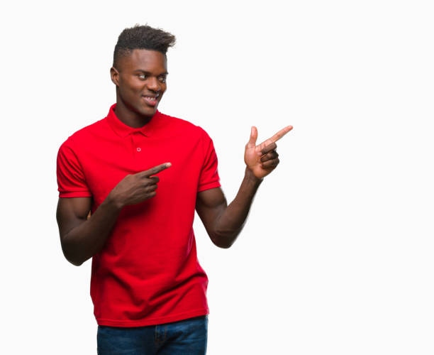 istock Young african american man over isolated background smiling and looking at the camera pointing with two hands and fingers to the side. 1055506576