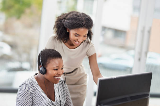 training her staff to handle any query that comes through - african descent customer service representative computer service imagens e fotografias de stock