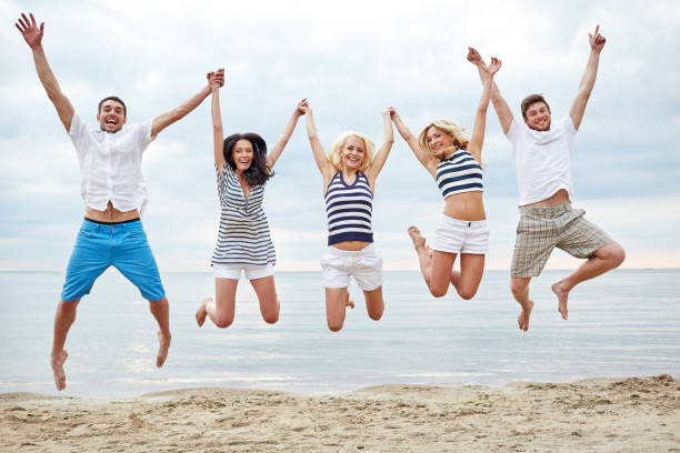 istock smiling friends in sunglasses walking on beach 1055513008