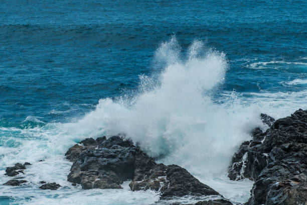 istock ocean waves crashing against black rocks on coast 1055515456