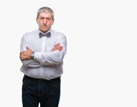 Handsome senior man wearing bow tie over isolated background skeptic and nervous, disapproving expression on face with crossed arms. Negative person.