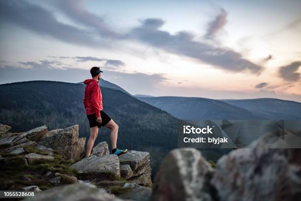 Uomo Che Celebra Il Tramonto Guardando La Vista In Montagna - Fotografie stock e altre immagini di Montagna