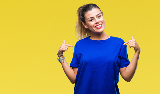 Young beautiful woman wearing casual blue t-shirt over isolated background looking confident with smile on face, pointing oneself with fingers proud and happy.