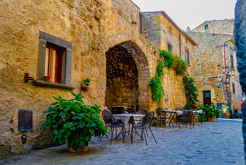 CIVITA DI BAGNOREGIO, VITERBO, LAZIO, ITALY - October 1, 2018: View of a typical alley with tables of restaurants and plants in the village among the most beautiful in Italy.