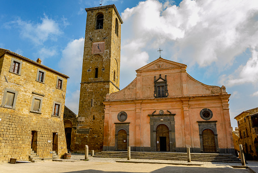CIVITA DI BAGNOREGIO, VITERBO, LAZIO, ITALY - October 1, 2018: Facade of the Chiesa di San Donato, with a Romanesque structure, the tower bell tower has two Etruscan sarcophagi at its base. Inside, works by the Perugino and Donatello schools.
