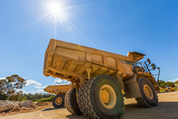 Sun shining on large yellow dumper trucks