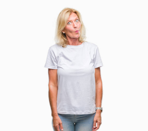 istock Middle age blonde woman over isolated background making fish face with lips, crazy and comical gesture. Funny expression. 1055533752