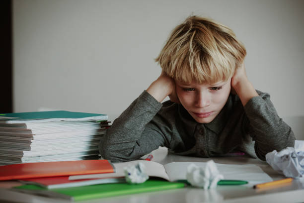 istock little boy tired stressed of doing homework, bored, exhausted 1055534278