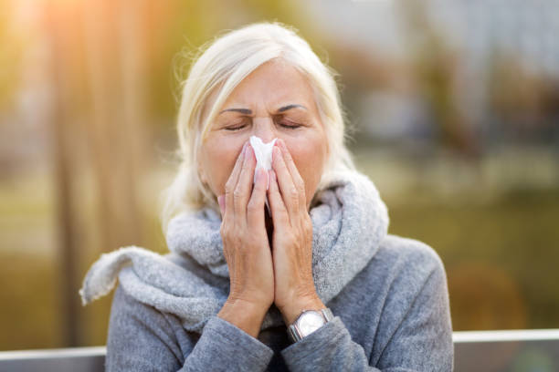 istock Sick woman blowing her nose 1055535804