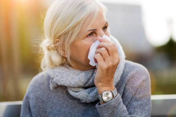 istock Sick woman blowing her nose 1055538496