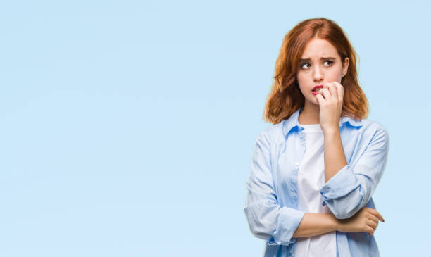 Young beautiful business woman over isolated background looking stressed and nervous with hands on mouth biting nails. Anxiety problem. Young beautiful business woman over isolated background looking stressed and nervous with hands on mouth biting nails. Anxiety problem. embarrassment stock pictures, royalty-free photos & images