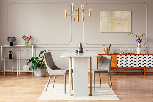 Colgante de estilo industrial, oro luz encima de una mesa de mármol excepcional en un interior moderno comedor con decoración ecléctica photo
