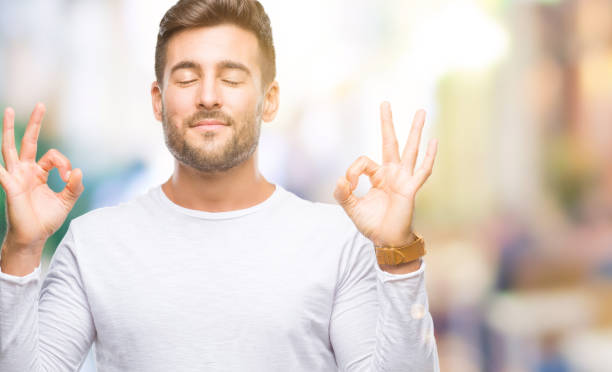 istock Young handsome man over isolated background relax and smiling with eyes closed doing meditation gesture with fingers. Yoga concept. 1055545922