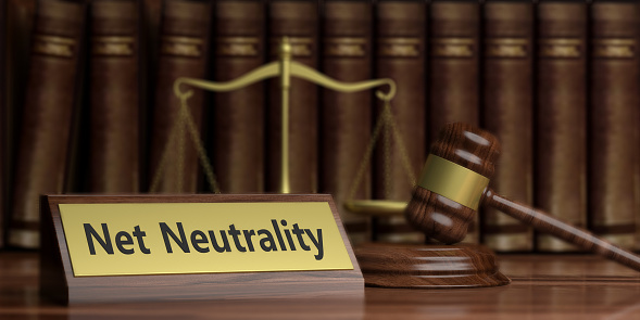 Net neutrality text on wooden desk, judge gavel and law scales background. 3d illustration