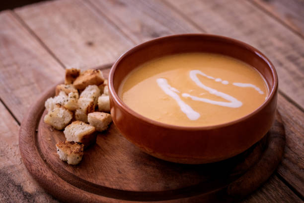 istock Home cooking, pumpkin soup with bread croutons, close-up 1055555392