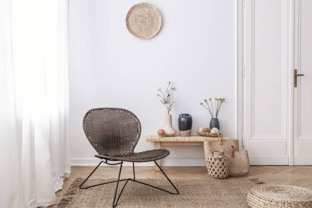 dark, modern wicker chair in a white living room interior with a wooden bench and decorations made from natural materials - modern handmade imagens e fotografias de stock