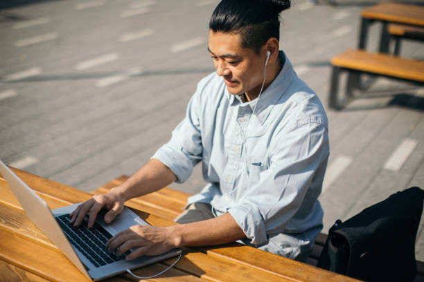 istock Mid adult Japanese is working on laptop 1055556474