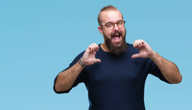 istock Young caucasian hipster man wearing sunglasses over isolated background looking confident with smile on face, pointing oneself with fingers proud and happy. 1055556528
