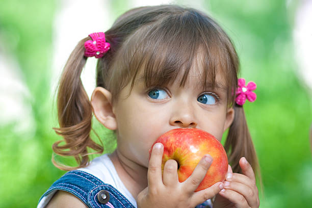 istock A little girl eating an apple outside 105555751