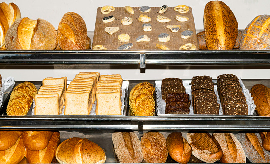 background with various types of fresh bread with wheat, seeds, grains, poppy