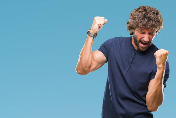 istock Handsome hispanic model man over isolated background very happy and excited doing winner gesture with arms raised, smiling and screaming for success. Celebration concept. 1055560050
