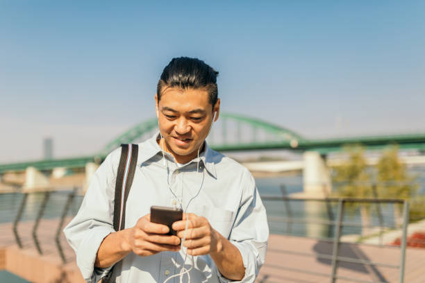 istock Mid adult Japanese using phone 1055560706