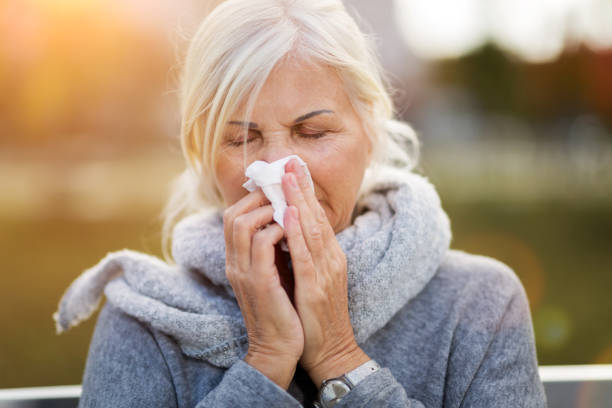 istock Sick woman blowing her nose 1055560846
