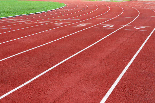 Photo of red running track for competition or exercise, as background. Sports concept. Colorful tone. Photo of red running track for competition or exercise, as background. Sports concept. Colorful tone. lane marker stock pictures, royalty-free photos & images