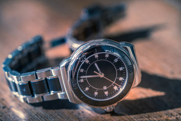 Close-up view of a sleek black wristwatch with minimalist design, perfect for fashion, branding, or time management themes, elegantly displayed on a modern dark background with dramatic lighting.