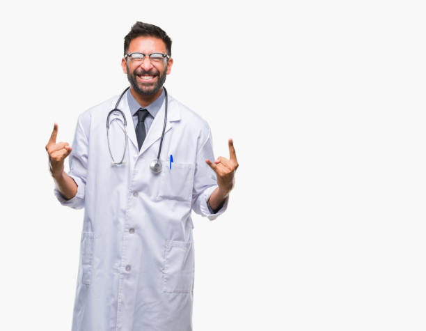 istock Adult hispanic doctor man over isolated background shouting with crazy expression doing rock symbol with hands up. Music star. Heavy concept. 1055583618