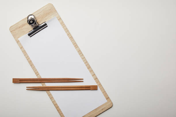 istock elevated view of blank menu and chopsticks on white surface, minimalistic concept 1055587758