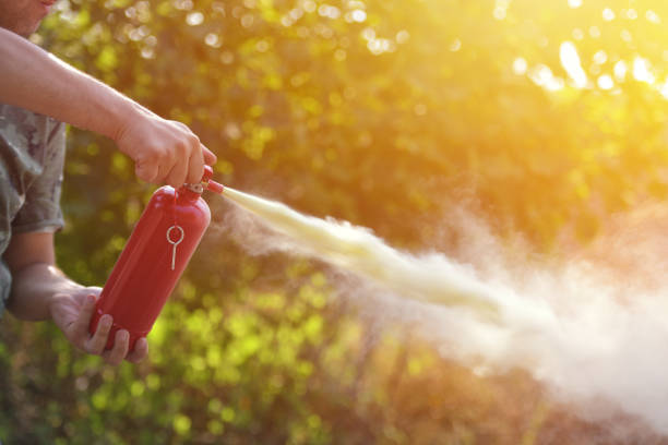 A man demonstrating how to use a fire extinguisher stock photo