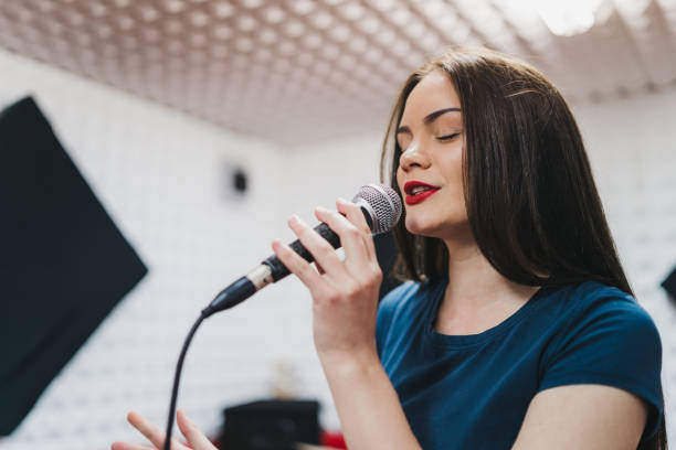 istock Young woman singing in recording studio 1055599414